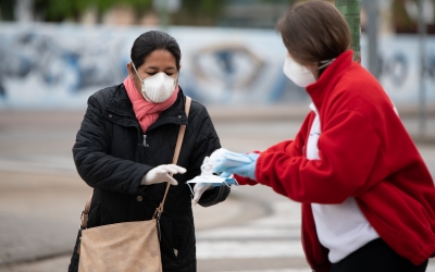 Una voluntària de Creu Roja repartint mascaretes/ Roger Benet